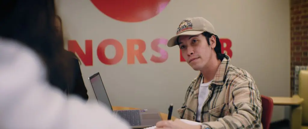 A scholar at a laptop in front of the Honors Lab sign at Minnesota State Moorhead