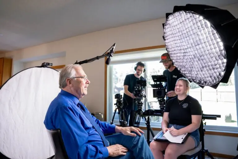 A Tellwell crew films an interview with a man in a blue shirt