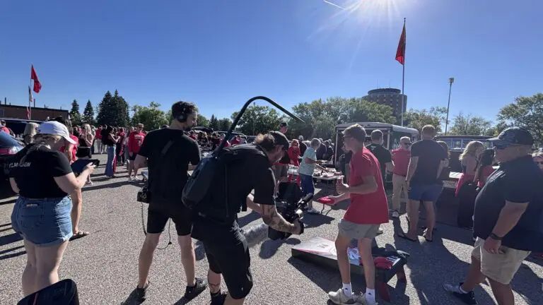 A Tellwell film crew shoots at a crowded campus tailgate