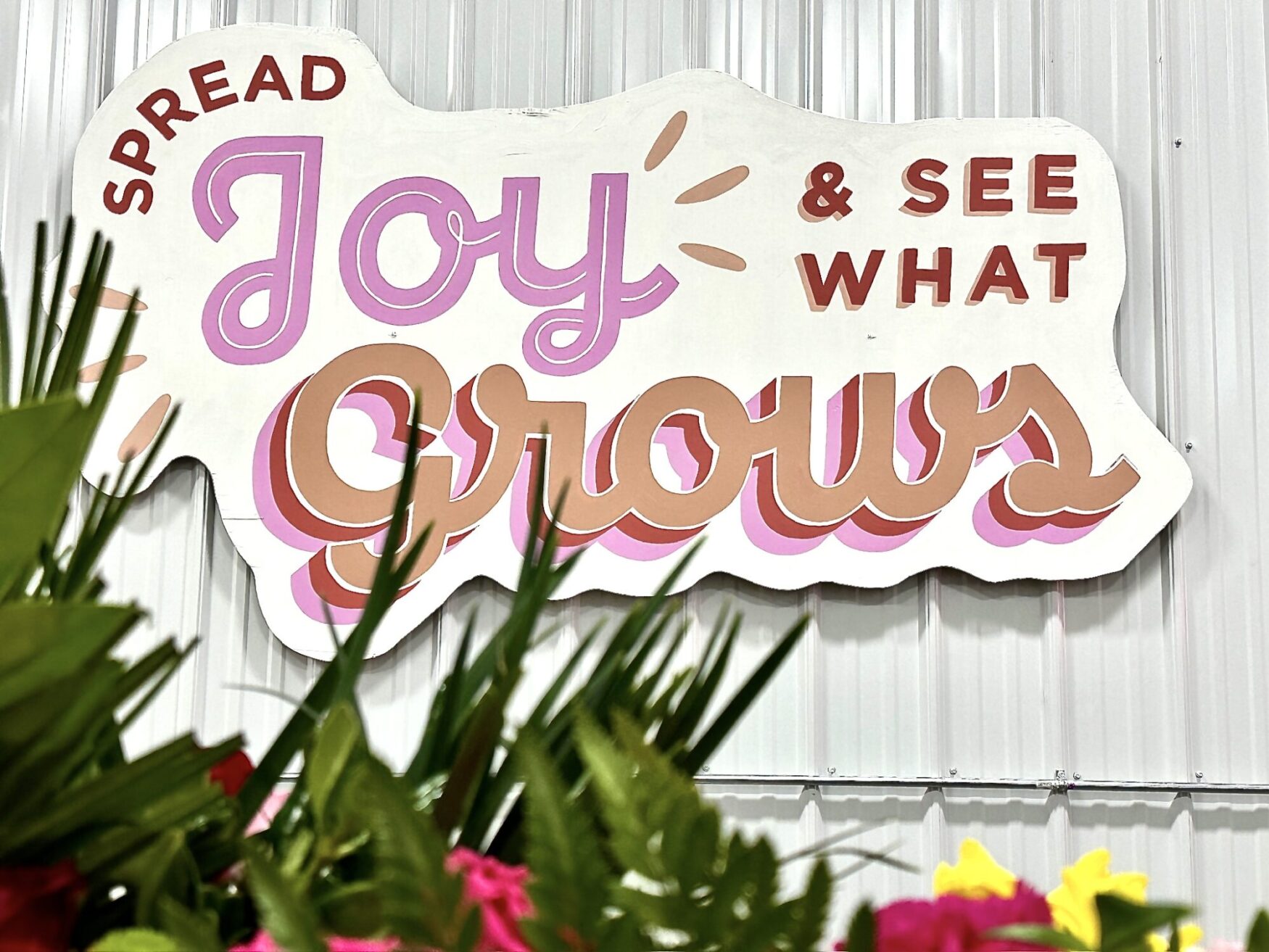 A sign that says "Spread Joy & See What Grows" at Hope Blooms