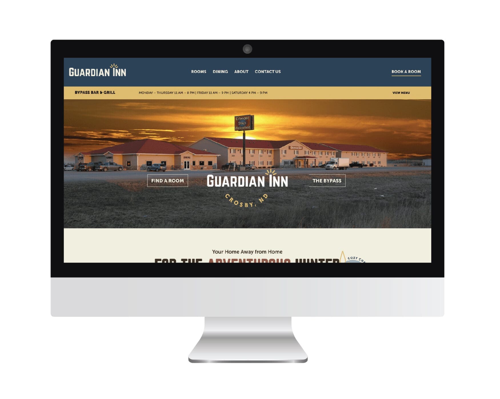 Homepage of the Guardian Inn website featuring an image of the inn at sunset, navigation links, and a main message promoting the inn for adventurous hunters, all displayed on a desktop monitor
