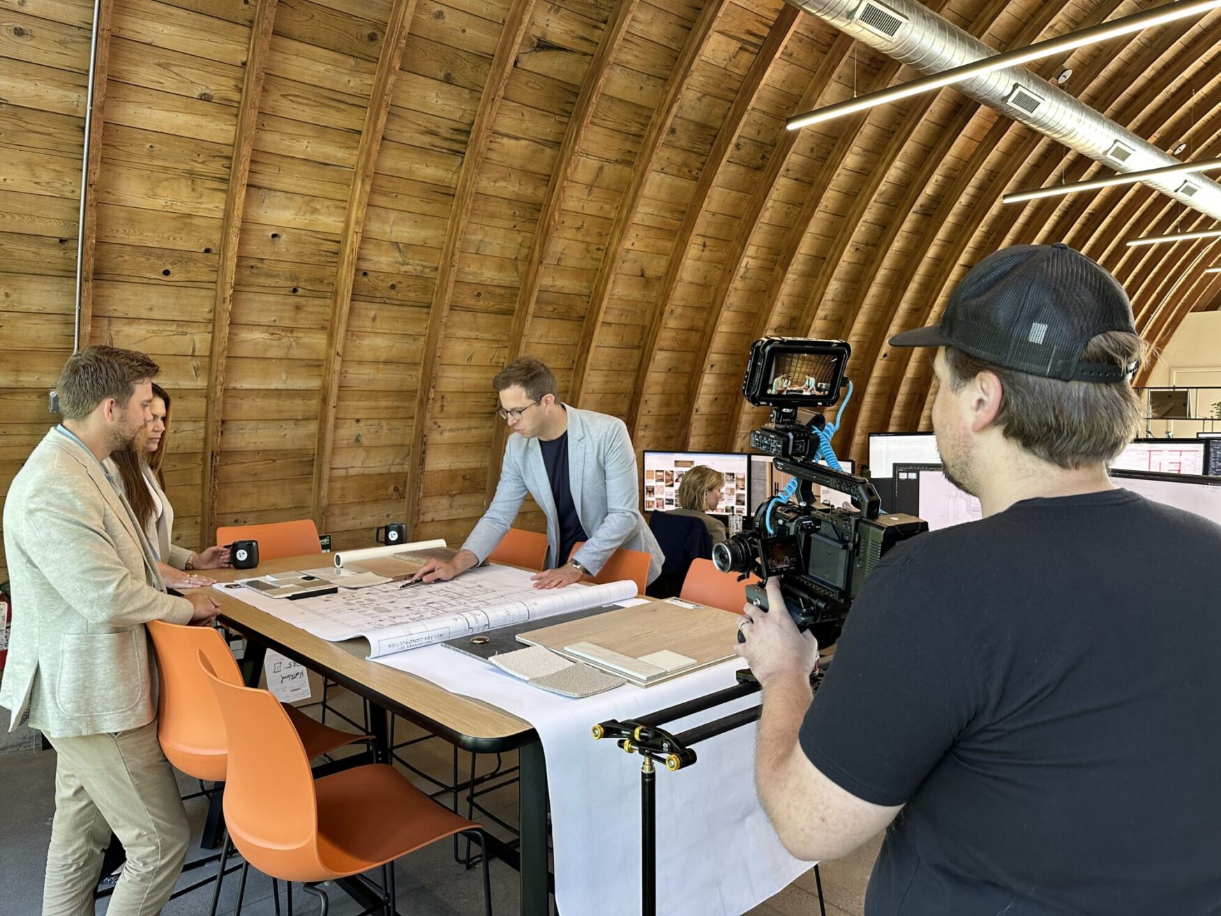 Matt films a group of people working on blueprints