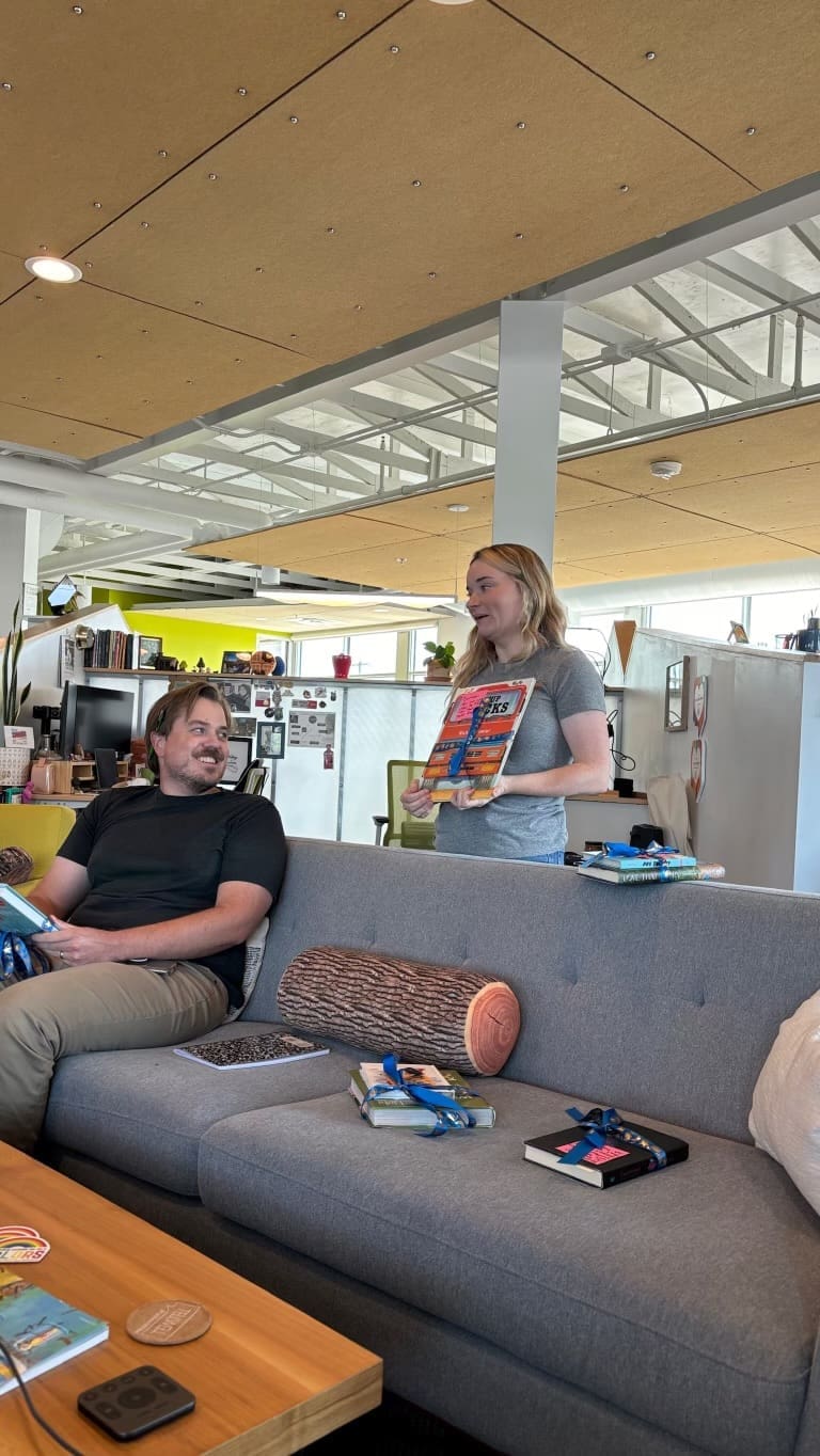 Emma explains the book she chose as Matt watches from the couch.