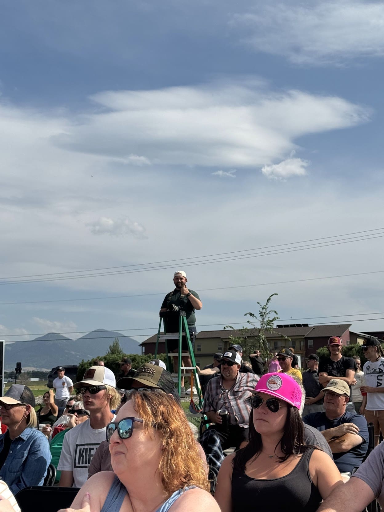 Max gives a thumbs up as he films from the top of a ladder