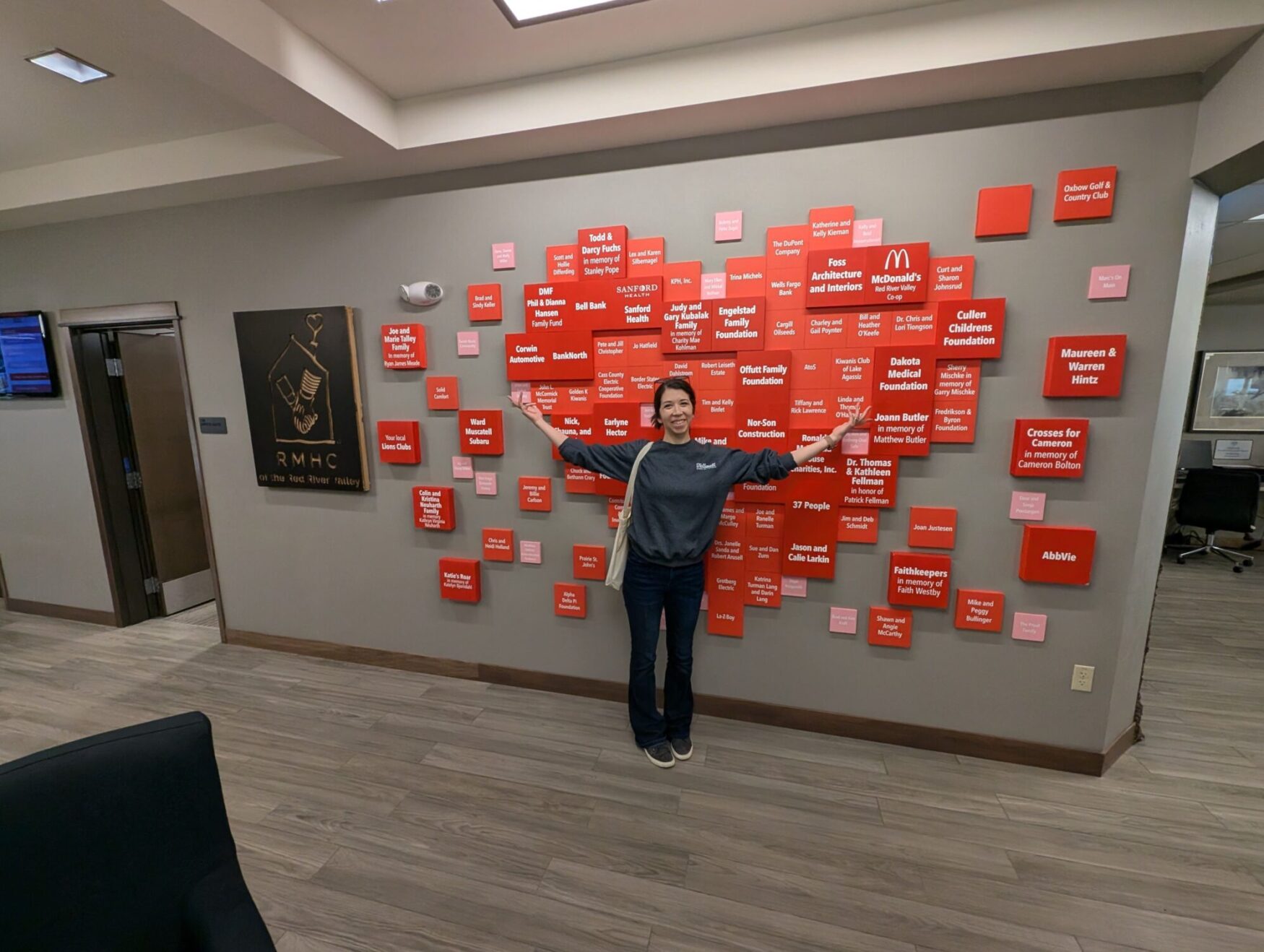 Jen stands in front of the RMHC of the Red River Valley's Hotdish at the House event
