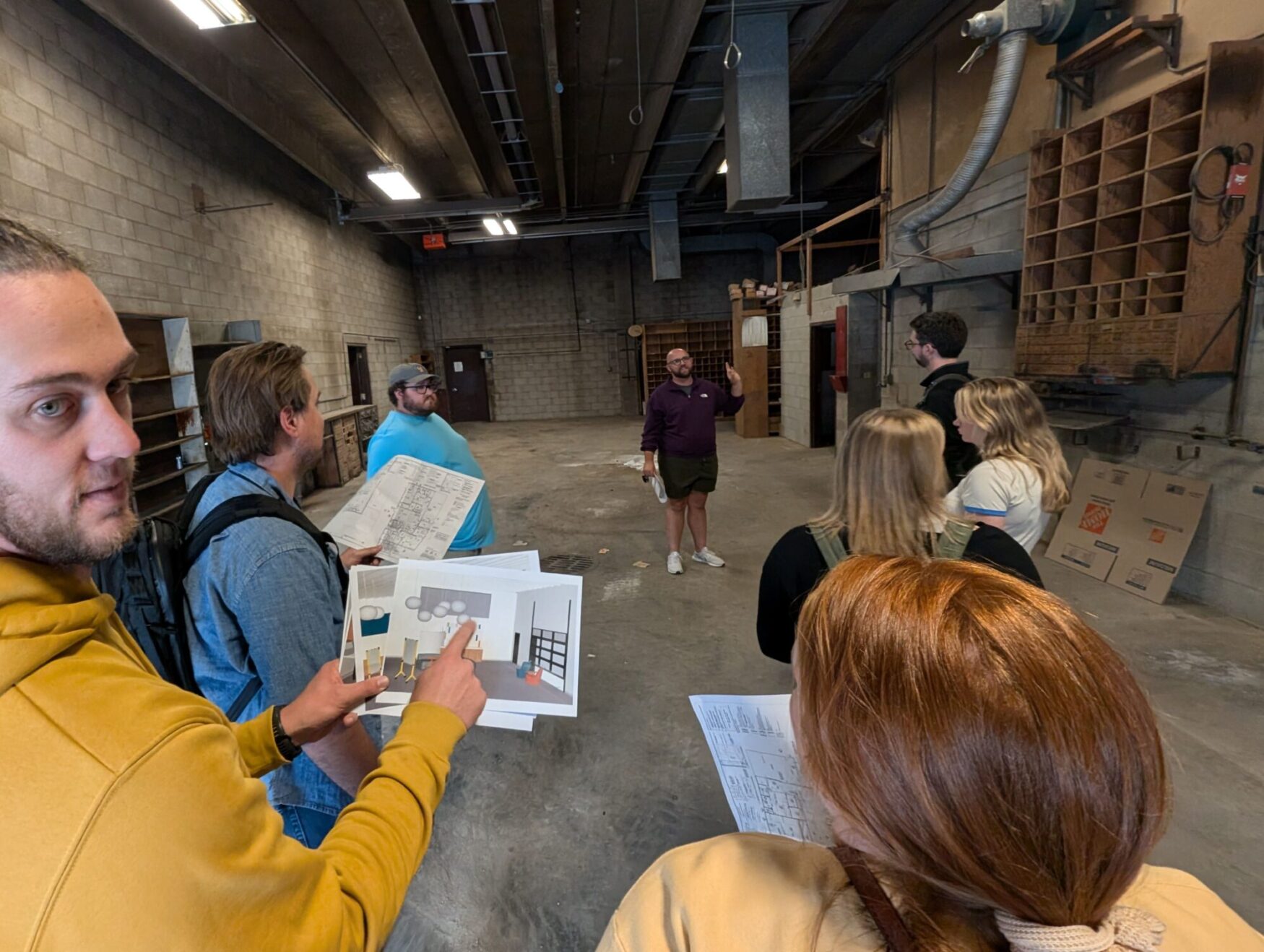 Max shows the Tellwell team around a gray bricked space