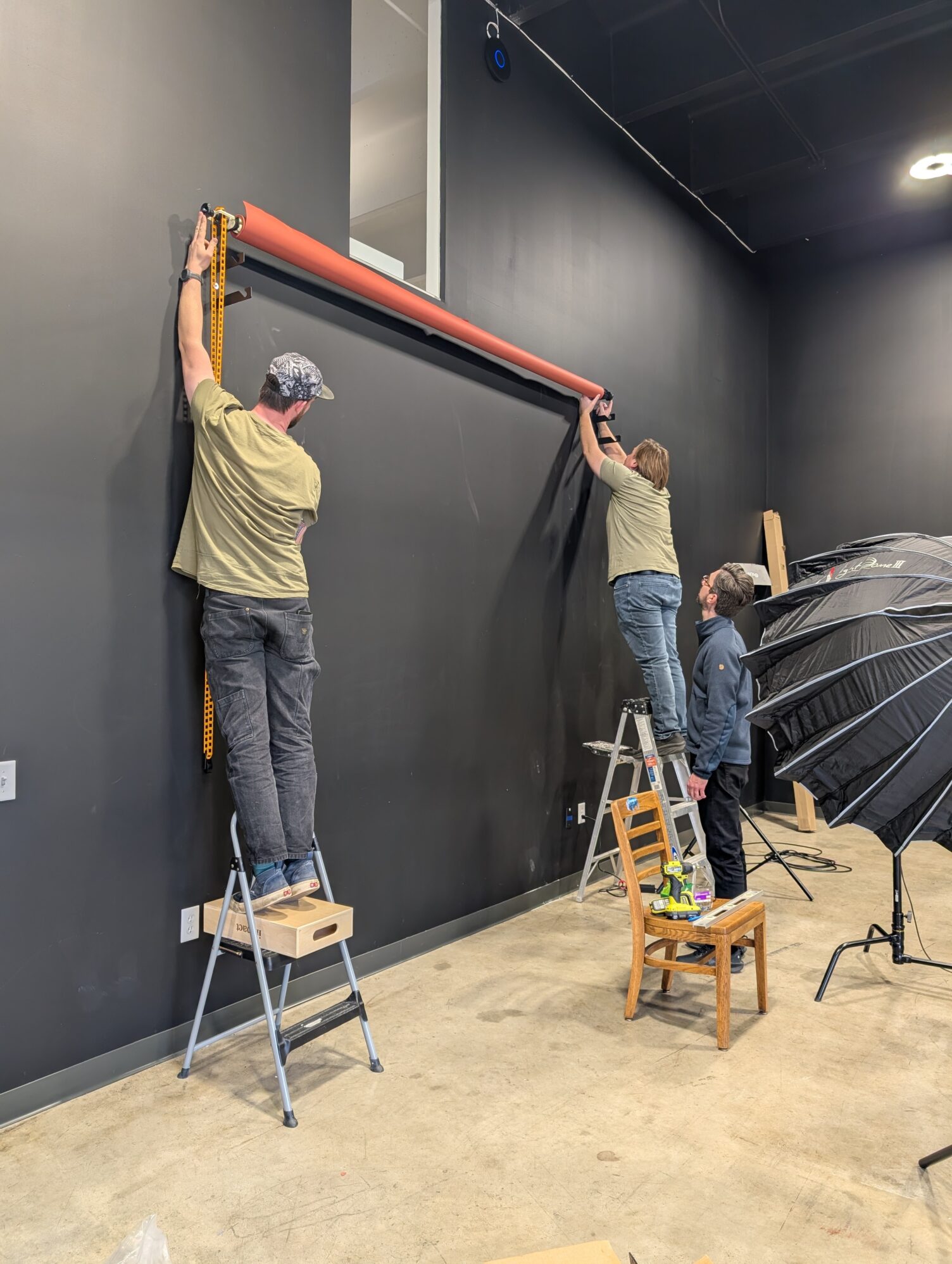 Duncan, Matt, and Lucas hanging new paper backdrops in the the new home studio space.